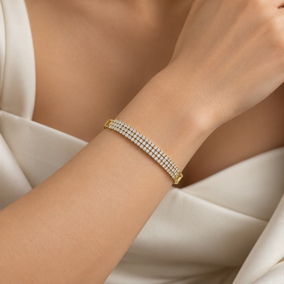 Model wearing an elegant gold tone multi-row sparkling bracelet on the wrist