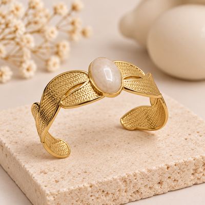 Anovra gold cuff bracelet with oval stone styled on minimal beige props
