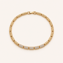 Gold crystal link bracelet on soft cream background