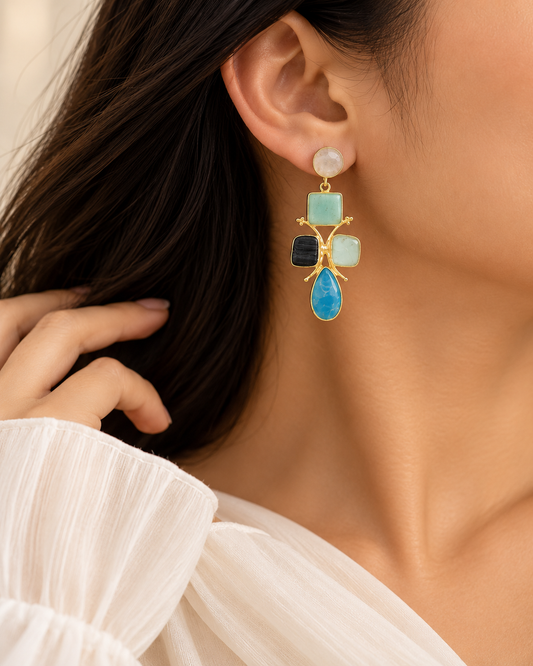 Close-up of multicolour statement earrings featuring round, square and teardrop gemstone-inspired settings.