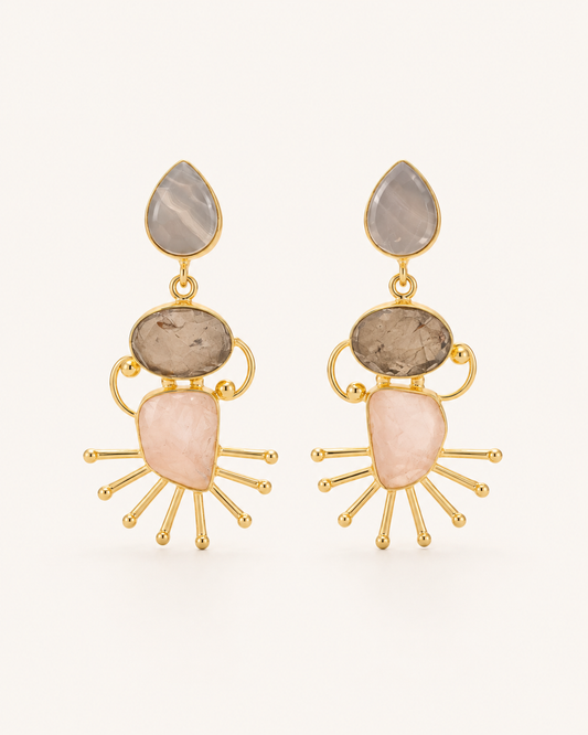 ANOVRA Celestial Stone Drops featuring blush-pink, smoky-grey and earthy-toned stones with gold sunburst detailing.