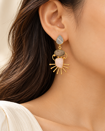 Model wearing elegant gold-tone multicolour stone drop earrings with artistic geometric detailing.