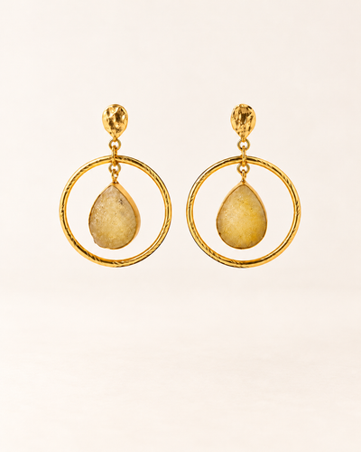 ANOVRA gold teardrop hoop earrings featuring textured circular frames and golden-yellow dangling stone accents.