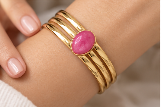 Close-up of Anovra pink teardrop triple-band gold-tone cuff bracelet worn on wrist