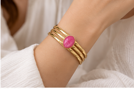Anovra pink teardrop triple-band gold-tone cuff bracelet worn on wrist, face not visible